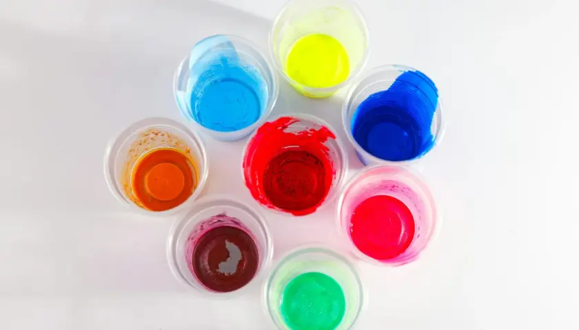 Kolorowe farby w kubeczkach, idealne jako jaka farba do plastiku na zewnątrz. Odcienie czerwieni, niebieskiego, zieleni, żółci, pomarańczu i różu.