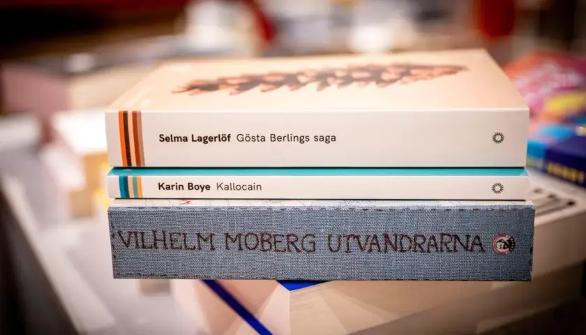En stapel böcker med Selma Lagerlöf, Karin Boye och Vilhelm Moberg. Ur ett annat person perspektiv ser man titlarna tydligt.