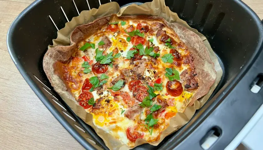 Pyszna tortilla z airfryer, z pomidorkami, serem i ziołami, gotowa do podania.
