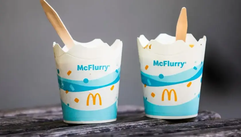 Dwa kubeczki McFlurry z drewnianymi łyżeczkami. Idealne na deser, ale warto sprawdzić mcflurry kcal przed spożyciem.