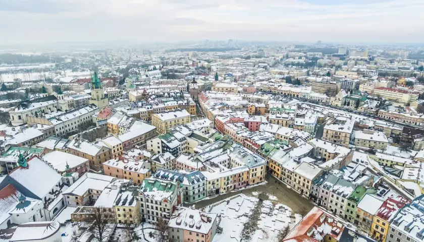 Zimowy krajobraz Lublina pokryty śniegiem. Idealne miejsce na ferie zimowe 2026 lubelskie, z kolorowymi kamienicami i zabytkowymi kościołami.
