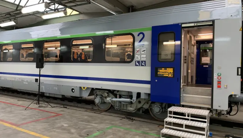 Wagon 175a w hali serwisowej, z otwartymi drzwiami i schodkami. Widać wnętrze z siedzeniami i numer wagonu "2".