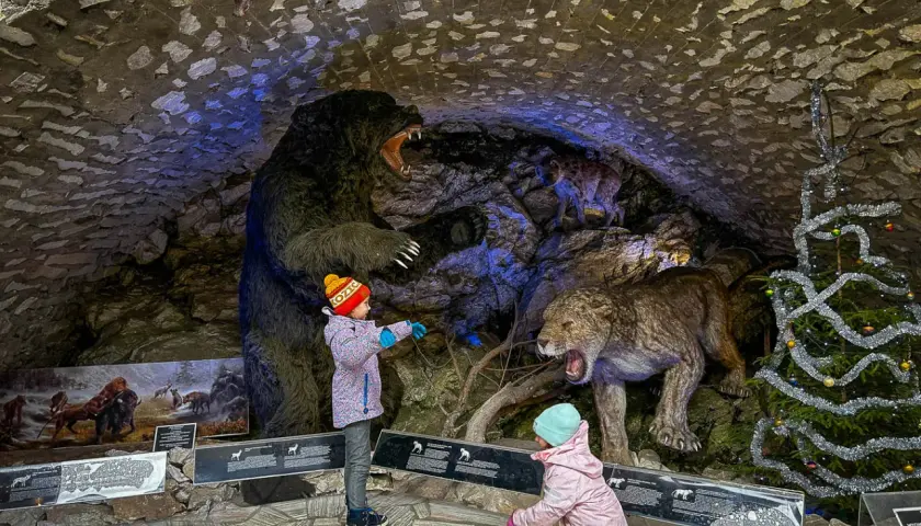 Dzieci zwiedzają jaskinię niedźwiedzia, podziwiając prehistoryczne zwierzęta. Bilety do tego miejsca są warte każdej ceny!
