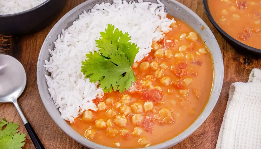 Herzhaftes veganes Kichererbsen-Curry mit Basmatireis, garniert mit Koriander. Ein köstliches Gericht für jeden Tag.