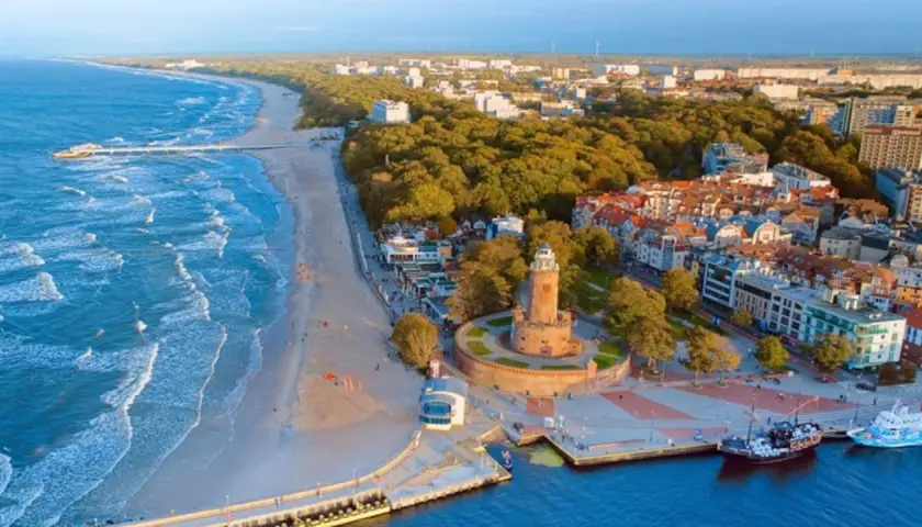 Malownicze miejscowości nad morzem z latarnią morską, plażą i portem.