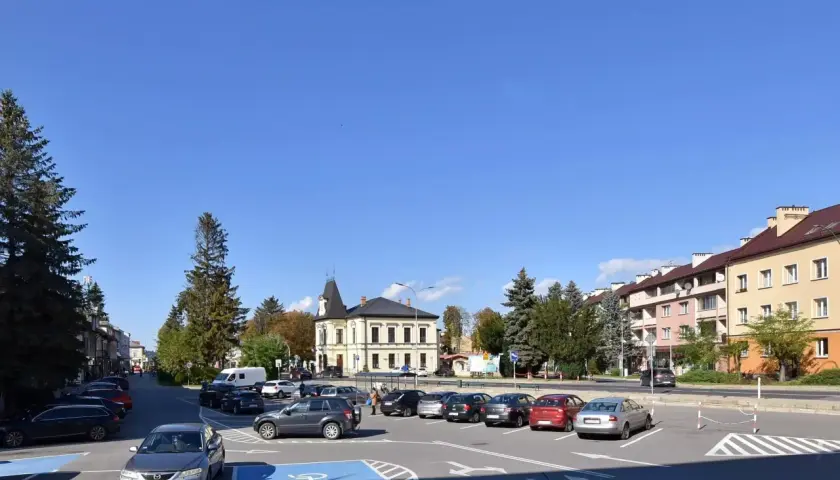 Urokliwe miasta w Bieszczadach, z parkingiem pełnym samochodów i charakterystyczną architekturą.