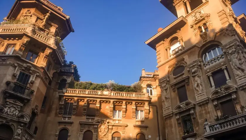 Edifici in stile liberty a Roma, con dettagli architettonici ricchi e un cielo azzurro intenso.