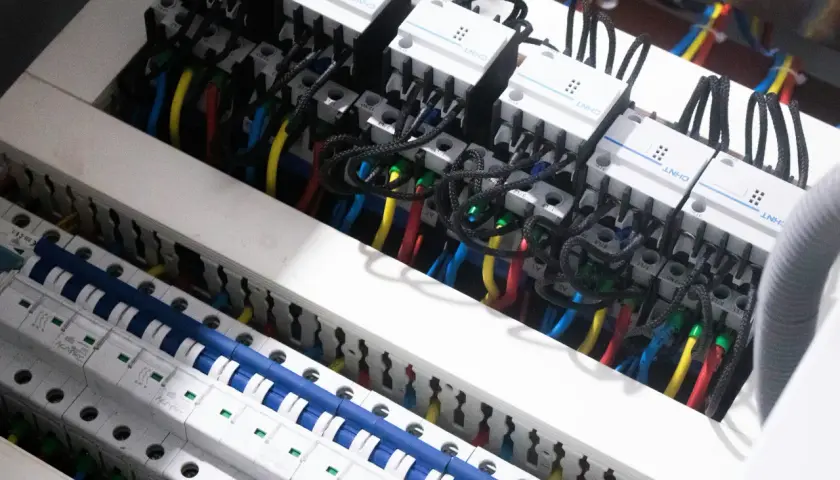 Wnętrze rozdzielnicy elektrycznej z przewodami i wyłącznikami. Widać moduły CHNT, które są częścią centrum elektrotechnicznego CB Elektron.