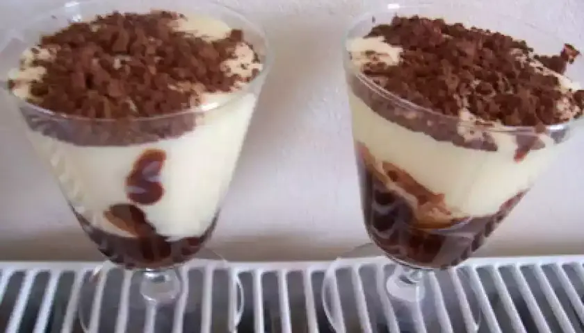 Deux verrines de tiramisu Nutella, crémeux et gourmand, saupoudrées de cacao. Un délice pour les yeux et les papilles.