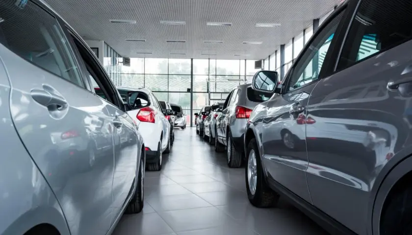 Auto km 0: cosa controllare. Diverse auto nuove in fila in un concessionario, pronte per essere visionate.
