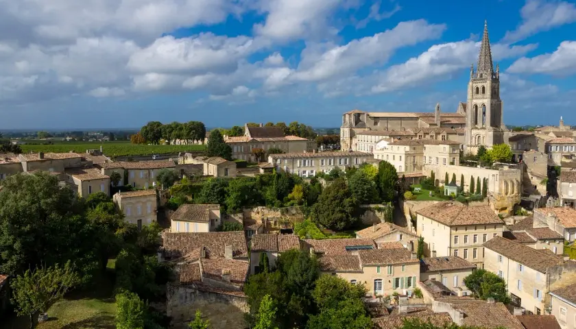 Vue aérienne de Saint-Émilion, ses toits de tuiles et sa collégiale, évoquant les meilleures années Saint-Émilion Grand Cru.