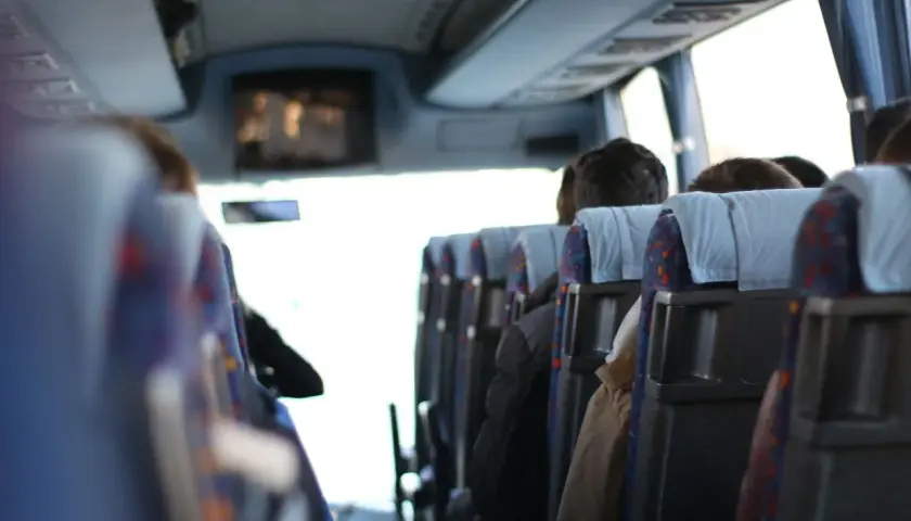 Wygodny transport gości weselnych autobusem. Widok z wnętrza pojazdu na siedzących pasażerów.