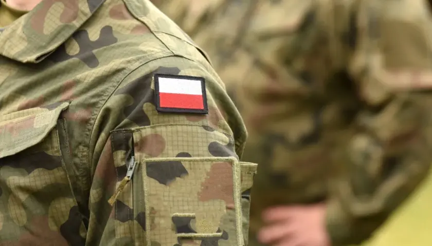 Fragment munduru wojskowego z naszywką z flagą Polski.
