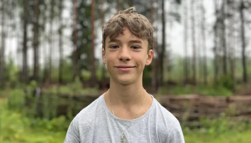 En leende Jack Bergnorth Henriksson står framför en skog.