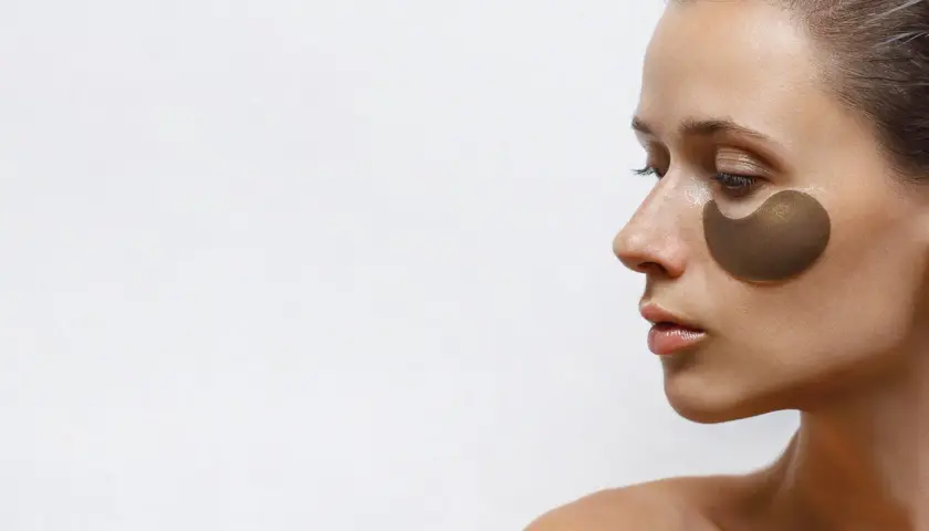 Kobieta z płatkami pod oczy, które obiecują widoczne retinol pod oczy efekty. Skóra wygląda na nawilżoną i odświeżoną.