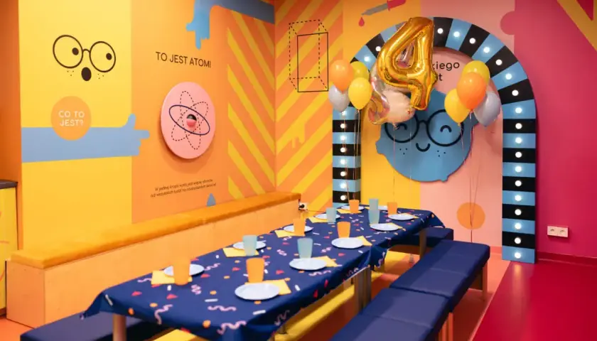Urodzinowa sala w Smart Kids Planet Warszawa. Kolorowe ściany, balony i stół gotowy na przyjęcie małych odkrywców.
