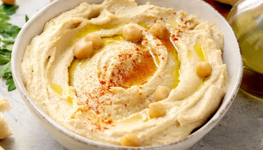 Hummus cremoso, con garbanzos, pimentón y aceite de oliva. Una deliciosa hummus receta tradicional, lista para disfrutar con pan.