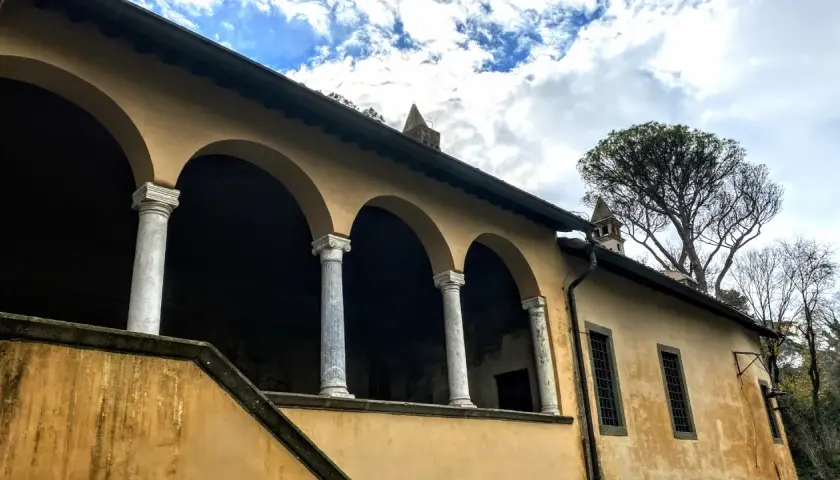 Portico con archi e colonne di marmo della casina cardinal Bessarione, con un grande albero sullo sfondo.