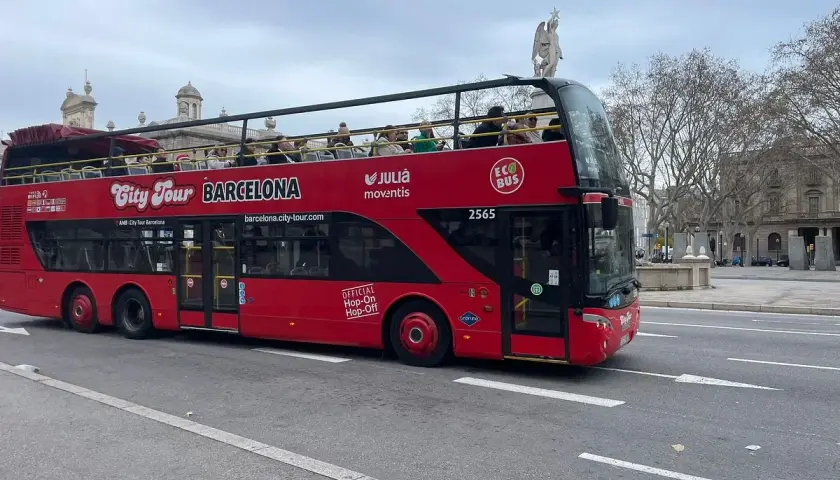 Roter Doppeldeckerbus für Barcelona Hop-On Hop-Off Touren fährt auf der Straße. Touristen genießen die Aussicht von oben.