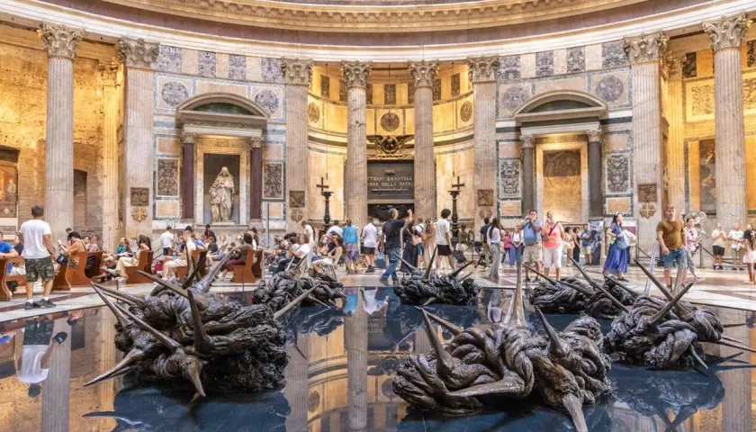 Intérieur du Panthéon de Rome, avec des sculptures modernes sur l'eau reflétant l'architecture antique.