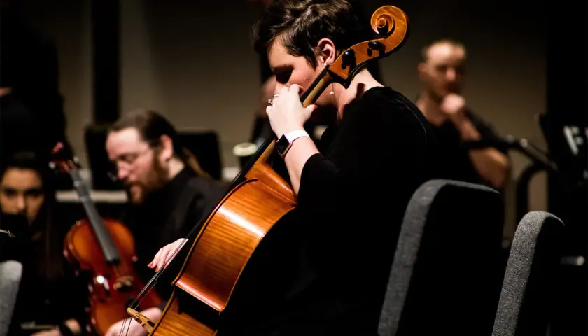 Une musicienne joue du contrebasse dans un orchestre.