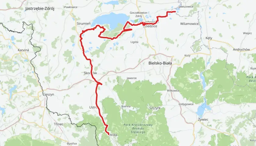 Mapa z zaznaczoną czerwoną trasą rowerową wzdłuż jeziora i terenów zielonych.