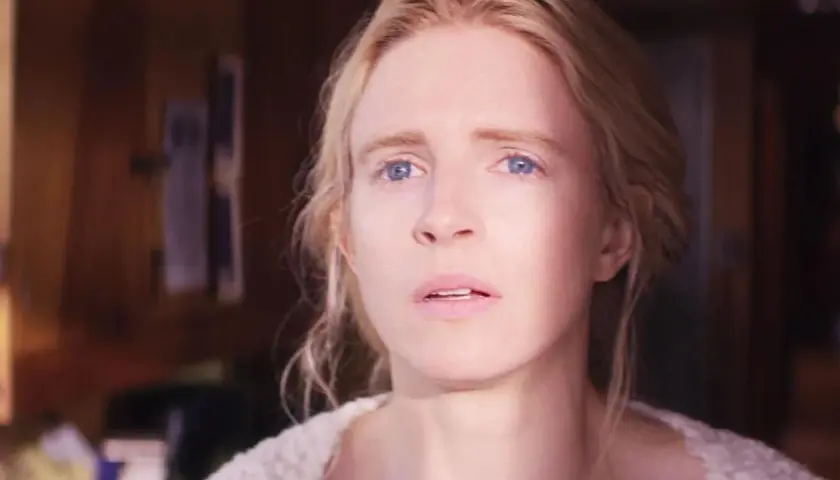 Le visage d'une femme blonde aux yeux bleus, l'air préoccupé, dans la happy série saison 3.