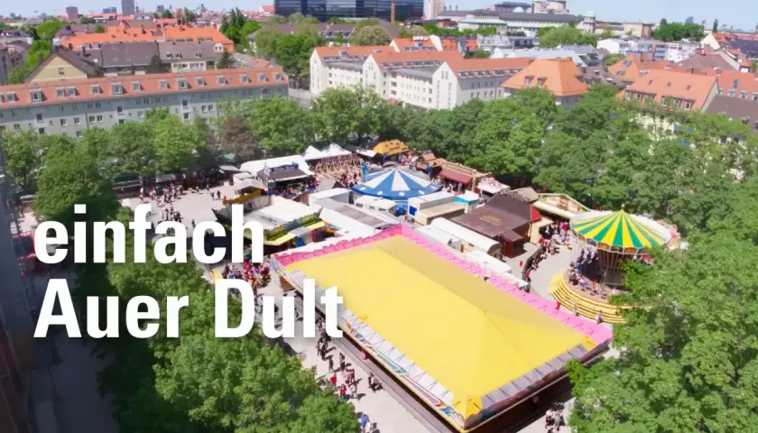 Buntes Treiben auf der Auer Dult mit Karussell, Buden und vielen Besuchern.