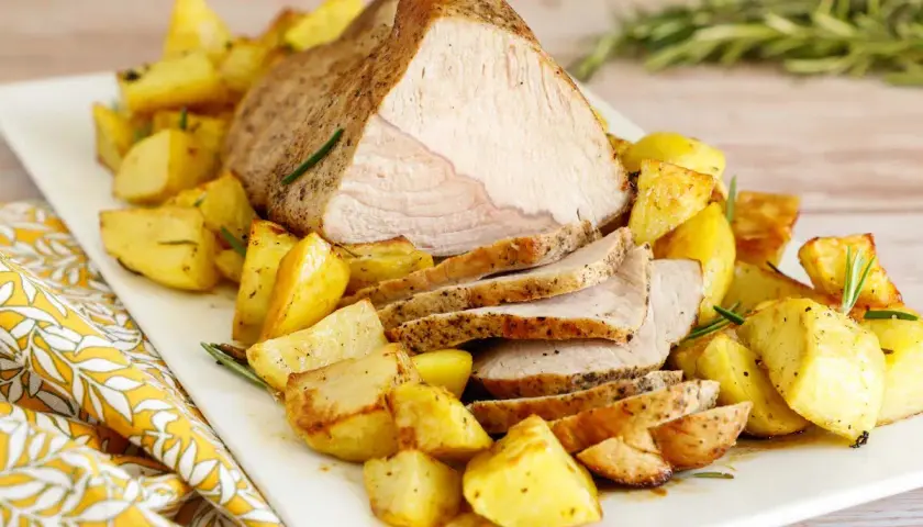 Succulento arrosto di vitello al forno, affettato e servito con patate arrosto dorate e profumate al rosmarino.