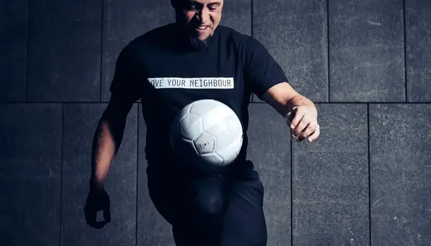 Roberto Carlos żyje i wciąż czaruje piłką! Legenda futbolu w czarnej koszulce z przesłaniem "LOVE YOUR NEIGHBOUR" bawi się białym futbolem.
