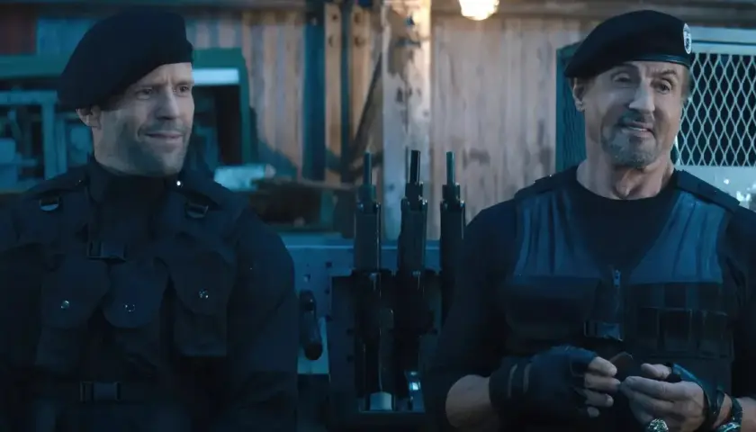 Jason Statham i Sylvester Stallone w czarnych beretach i kamizelkach taktycznych, gotowi do akcji w filmie "Niezniszczalni 5".