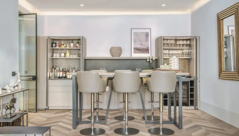 Modern bar area with sleek bar stools. The question of whether bar stools should match dining chairs is answered by this elegant setup.