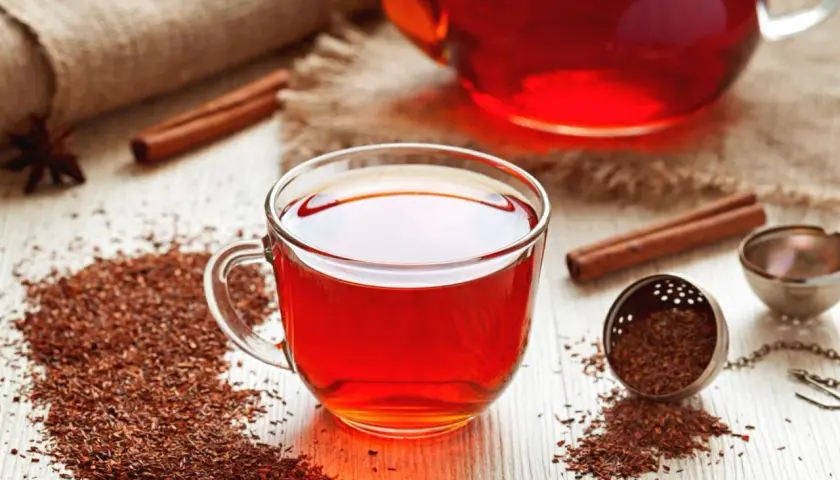 Aromatyczny rooibos zielony i czerwony w filiżance i dzbanku, z cynamonem i anyżem.