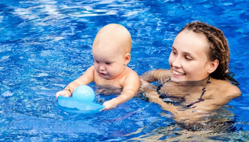 Mama z niemowlakiem w basenie. Po kąpieli można wyjść na dwór z niemowlakiem, gdy jest ciepło i dziecko jest dobrze osuszone.