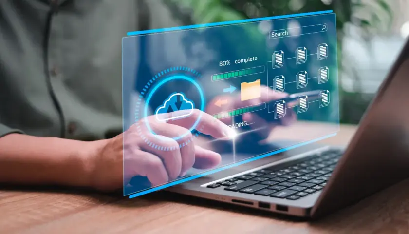 Interface numérique montrant des icônes de documents et un dossier, avec une barre de progression. Un doigt interagit avec l'écran, illustrant des solutions de dématérialisation.