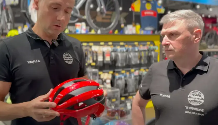 Wojtek prezentuje czerwono-czarny kask rowerowy.