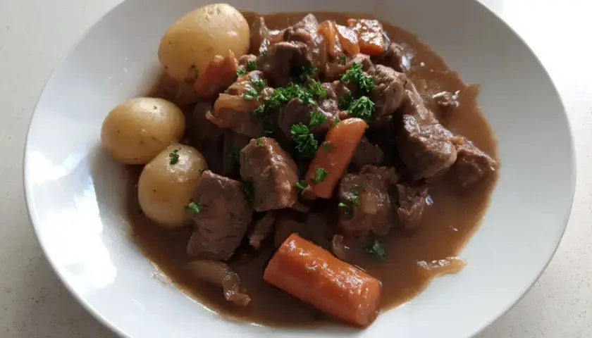En härlig fransyska gryta med möra köttbitar, mjuka potatisar och saftiga morötter, toppad med färsk persilja.