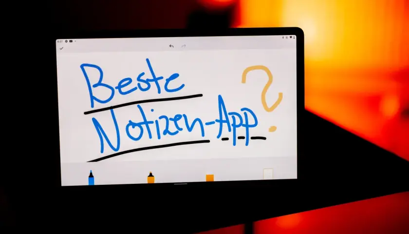 Auf einem Tablet steht in blauer Schrift "Beste Notizen-App?". Ein gelbes Fragezeichen und ein Punkt ergänzen die Frage. Ein gutes Lesezeichen für digitale Notizen.