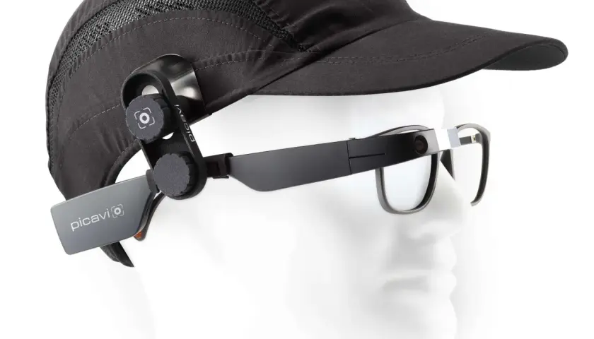 Ein schwarzer Hut mit einer Kamera, die per Vision gesteuert wird, ist an einer Brille befestigt.