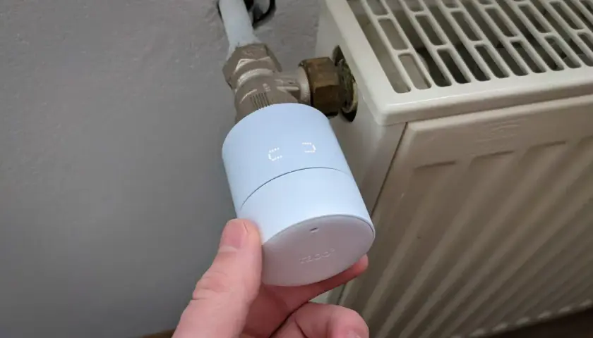 tado Kindersicherung: Ein weißer Thermostatkopf mit Display wird an einem Heizkörperventil montiert.