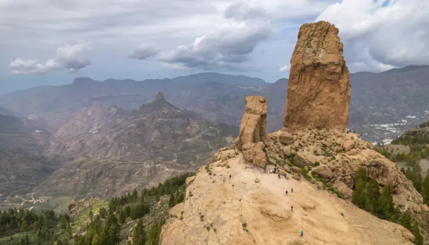 Majestatyczne skały Roque Nublo na Gran Canaria, z turystami podziwiającymi krajobraz.
