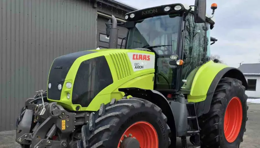 Ciągnik Claas Axion 810 w kolorze limonkowym, gotowy do pracy na polu.