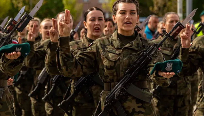 Żołnierze w mundurach, z karabinami i bagnetami, składają przysięgę. To obraz z ćwiczeń dobrowolnej zasadniczej służby wojskowej.