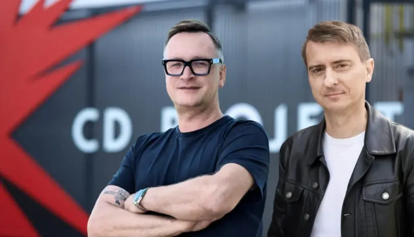 Dwóch mężczyzn na tle logo CD Projekt. Analiza przyszłości firmy.