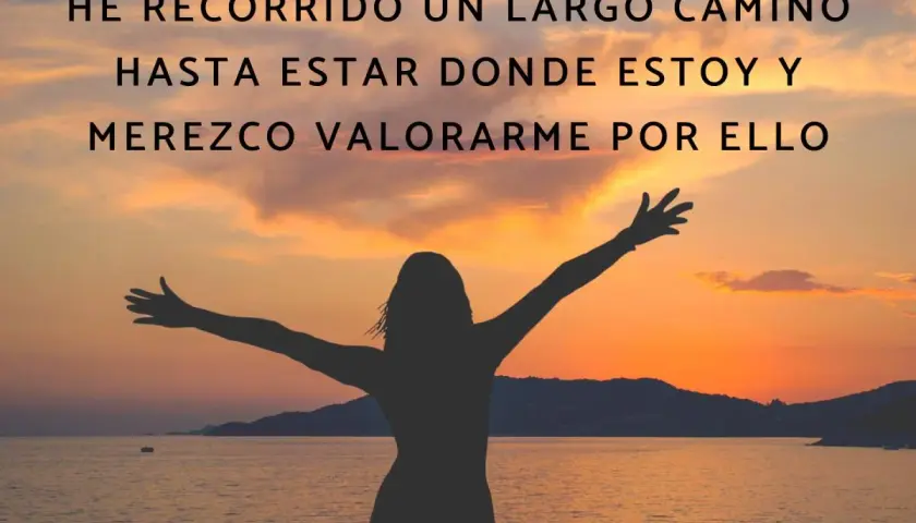 Silueta de persona con brazos extendidos al atardecer, celebrando un camino recorrido. Frases motivadoras para el positivo pensamiento y la autoestima.