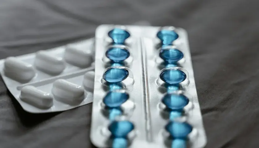 Dwa blistry leków: jeden z białymi kapsułkami, drugi z niebieskimi, prawdopodobnie pregabalin zentiva.