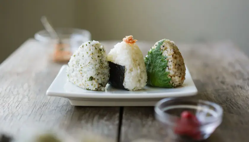 Three delicious rice balls with seaweed, seasoned and ready to eat.