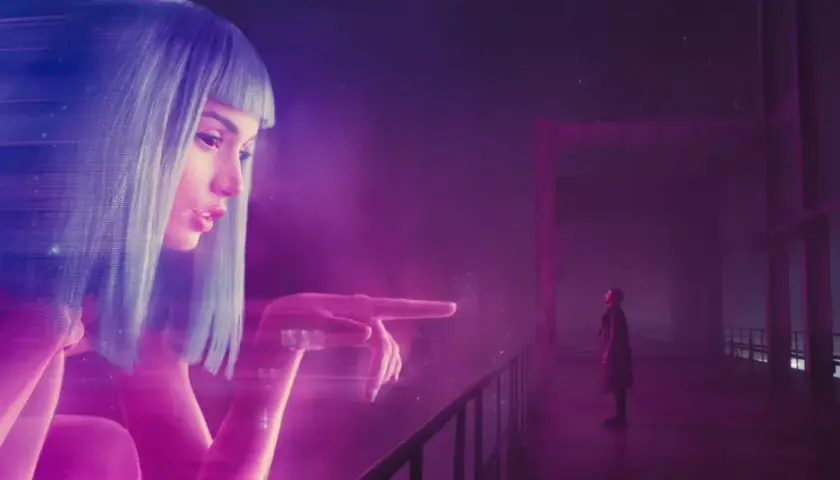 Joi, un'ologramma, interagisce con K su un ponte. Un'immagine iconica per la blade runner 2049 recensione.
