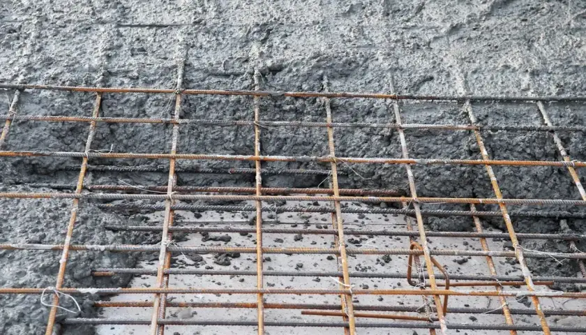 Siatka zbrojeniowa, na której widać świeży, mokry beton. To właśnie chudziak, podstawa konstrukcji.