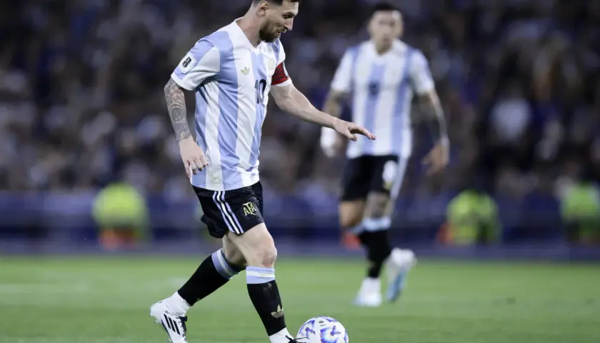 Lionel Messi w koszulce Argentyny prowadzi piłkę. Jego wzrost nie przeszkadza mu w byciu jednym z najlepszych piłkarzy świata.